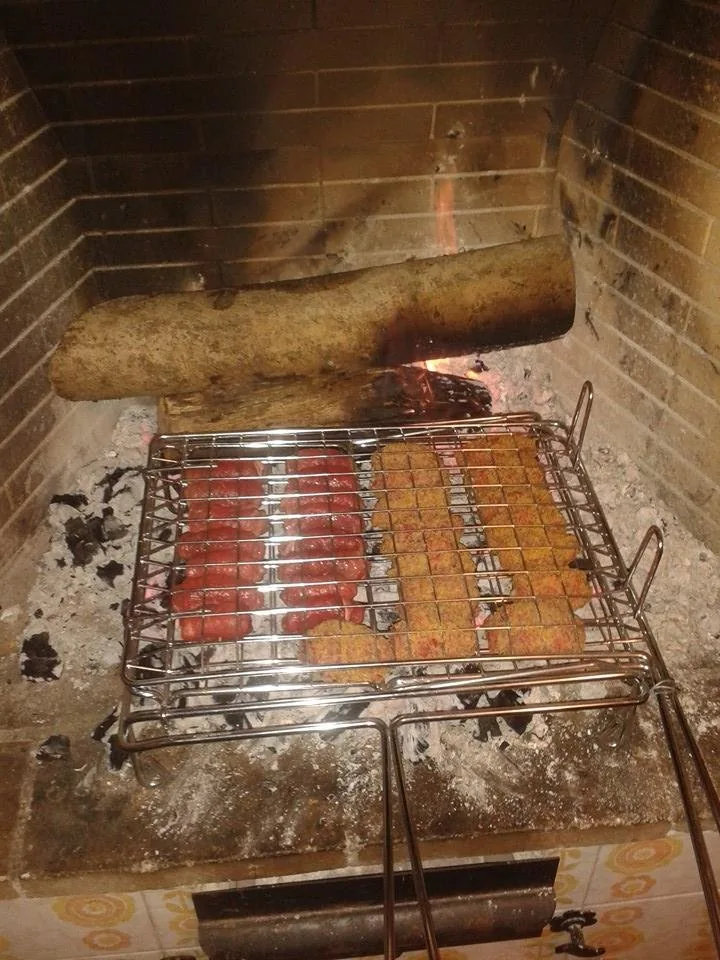 Bombette e salsicce pugliesi sulla graticola sopra la brace del fornello